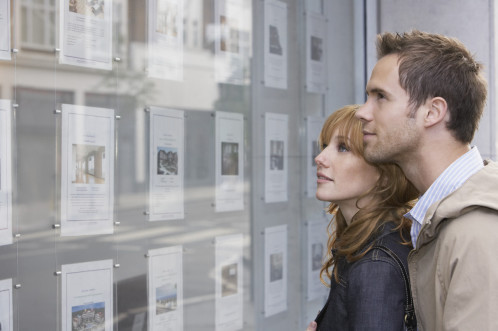 Young couple looking in an eastate agents window