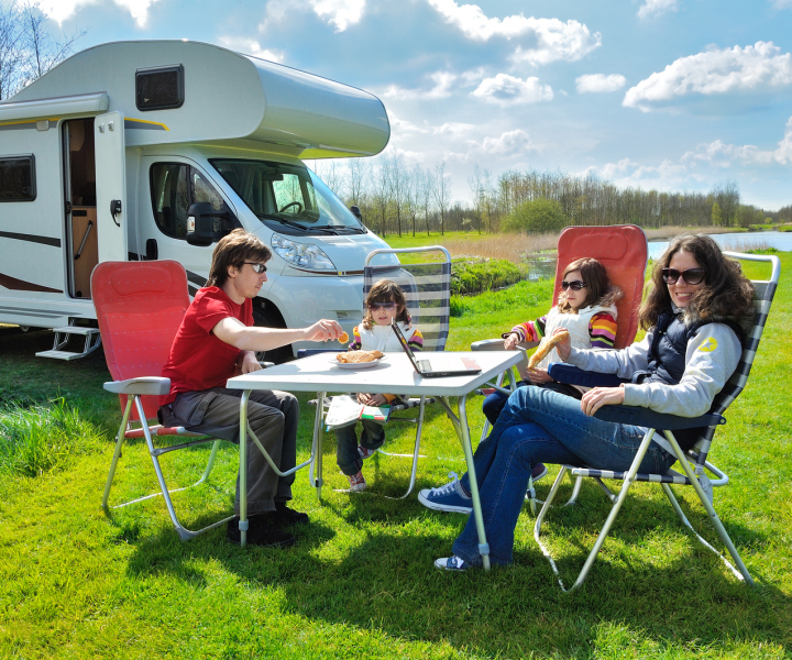 Family sitting at a table in front of their motorhome