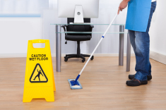 Wet floor sign and man mopping the floor